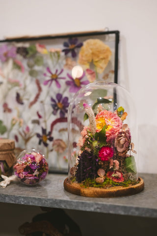 a glass dome with flowers inside